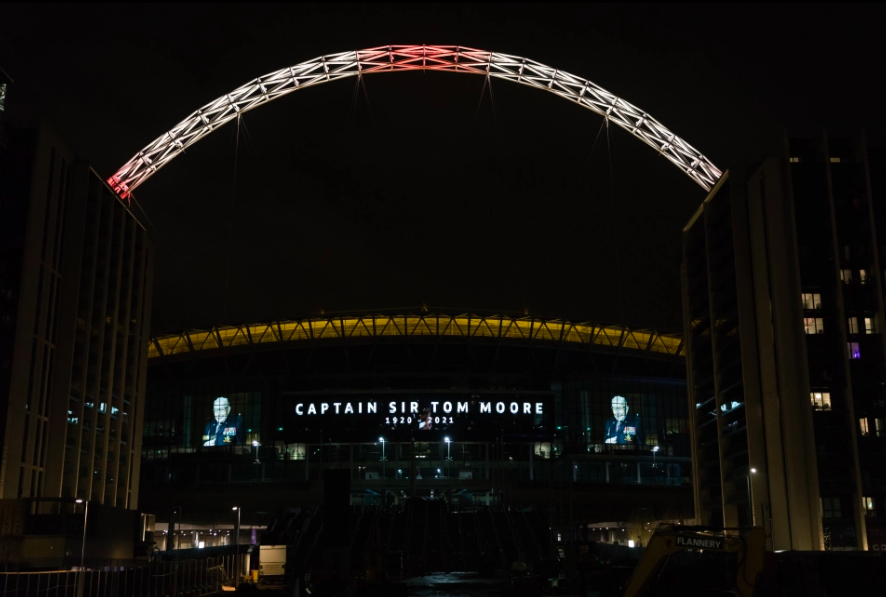 Wembley Stadium lit up in tribute to Captain Sir Tom Moore. Credit to Avalon